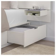 a white bed with drawers underneath it