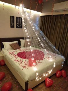 a bed that has some lights on the headboard and it is decorated with hearts