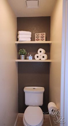 a toilet in a bathroom with shelves above it