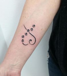 a woman's arm with a dog paw and letter j tattoo on the wrist