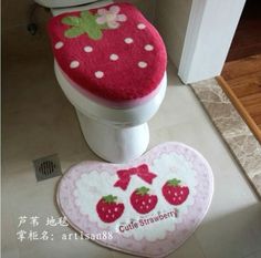 a toilet seat cover and rug in the shape of a strawberry