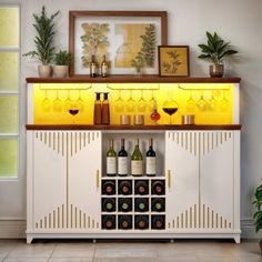 a white cabinet with wine glasses and bottles on the top, next to potted plants