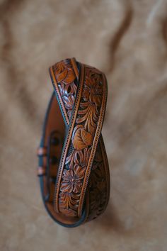 All of our Hand Tooled Belts are made one at a time in our shop by Clint Wilkinson. Craftsmanship of this nature takes a tremendous amount of time, so please be patient. Sizing (Please read carefully) Best Results: Take your old belt and measure from leather "fold" (A) to the current hole you're using (B). The results in inches will be the belt size you need to order. Alternative: Take your waist size in pants and add 2 inches, this will be the belt size you need to order Watch Video On Belt Mea Carved Leather Belt, Stamped Leather Belt, Hand Tooled Leather Belt, Tooled Belts, Cowboy Outfit For Men, Tooled Belt, Cowboy Outfit, Tooled Leather Belts, Belt Holster