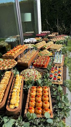 many trays of food are on the table outside