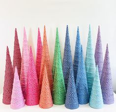 there are many different colored cones on the white table top, each with one cone at the bottom