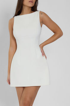 Classic elegance meets feminine glamour in our new Estelle Dress. Featuring a sleeveless boat-neck and open back, this white mini dress sculpts and shapes the body in all the right places. Cut from premium, high density knit fabric, the extra seam details throughout create a sculpting effect while the flared skirt provides a slight shaping affect for a figure-flattering fit. Boat Neck White Dress Short, Short Structured Dress, Classy White Dress Short, Photoshoot Dress Ideas Outfit, Preference Dresses, Jet Photoshoot, White Graduation Dress College Classy, Azores Wedding, Mini Reception Dress