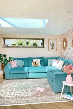 a living room with blue couches and pink walls