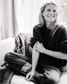 a woman sitting on top of a couch next to a window