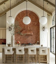 a large kitchen with an island and bar stools in front of the counter top