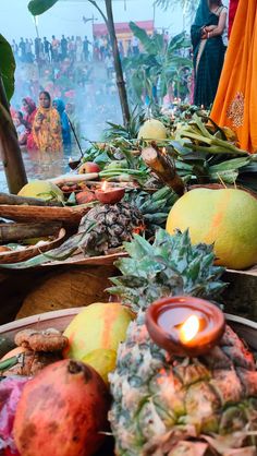 there are many different fruits on the table and people in the background looking at them