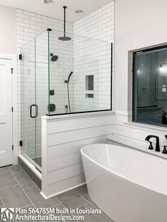 a white bath tub sitting next to a window in a bathroom with gray tile flooring