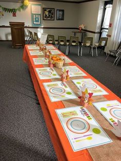 a long table is set up with place mats and napkins for the guests to eat