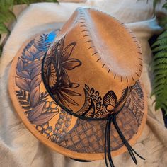 Small Brim Fedora in Khaki. Hat is adjustable from the inner crown for a tighter fit. Burned using Pyrography Techniques. Each Hat is freehanded, making it a hat of its own and a One of a kind. Hats made by Piper come with a Signature travel/dust bag and a handcrafted Macrame Hat Wall Hanger. Hat is sealed for weather for up to 12 months. Wood Burn Hat, Artistic Adjustable Hat Bands For Fedora, Artistic Adjustable Hat For Rodeo, Brown Hand Painted Short Brim Hat, Adjustable Hand Painted Fedora With Curved Brim, Adjustable Brimmed Hand Painted Fedora, Adjustable Hand Painted Brimmed Hat, Hand Painted Adjustable Brimmed Fedora, Adjustable Wide Brim Hand Painted Hats