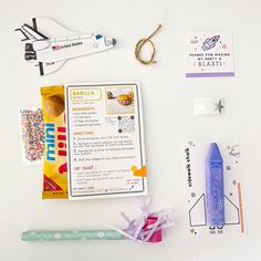 an assortment of crafting supplies are laid out on a white surface with space shuttles