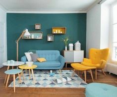 a living room with blue walls, yellow chairs and an area rug on the floor