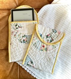 two cell phones sitting on top of a table next to a white doily with flowers