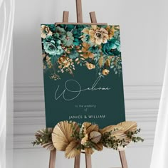 an easel with flowers and greenery on it