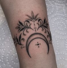 a black and white photo of a tattoo design on the left arm, with a crescent in the middle