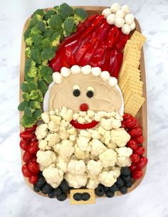 a platter filled with vegetables and a santa clause made out of cauliflower