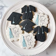 decorated cookies in the shape of graduation caps and tassels on a white plate