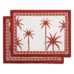 two red and white place mats with palm trees on them