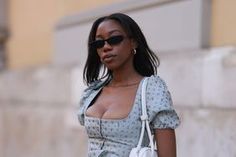 a woman in a blue dress carrying a white purse