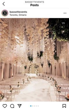 a wedding ceremony setup with white chairs and chandeliers hanging from the ceiling,