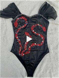 a black bodysuit with red and white beads on it