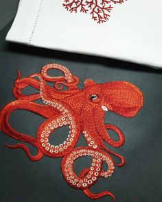 an orange octopus is on the back of a gray jacket with red and white trim