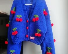 a blue cardigan with cherries on it