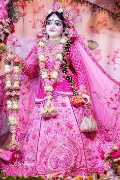 a woman dressed in pink and white poses for the camera