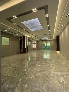 an empty room with large marble floors and skylights on the ceiling is lit by recessed lights