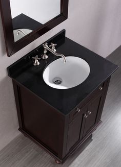 a white sink sitting under a mirror on top of a wooden vanity next to a wall