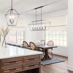 a large kitchen with an island in the middle and lots of chairs at the end