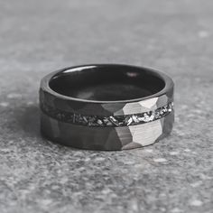 a black and white wedding band with silver inlays on the inside of it