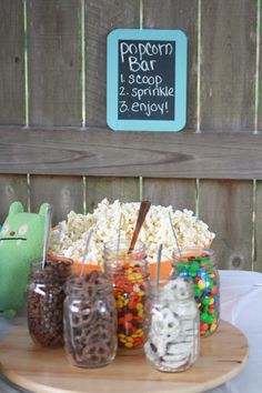 a wooden table topped with jars filled with candy