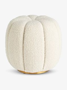 a white poufce sitting on top of a wooden stand