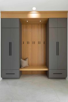 an empty bench in the middle of a room with cupboards and pillows on it