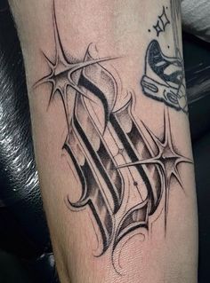 a black and white photo of a tattoo on someone's leg with the letter k in it