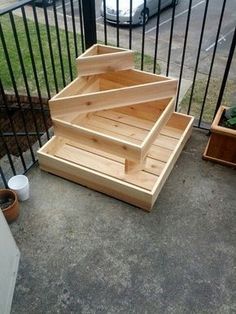 the stairs are made out of wood and have been placed on the ground near some potted plants