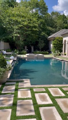 an outdoor swimming pool surrounded by grass