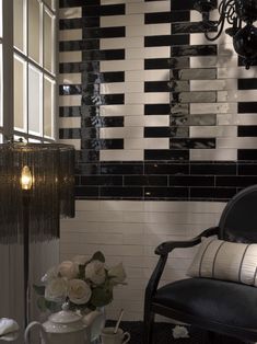 a black and white tiled bathroom with flowers in the vase