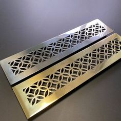 two metal trays sitting on top of a gray table next to eachother