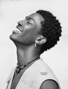 a woman with an afro is smiling and looking up at the sky in black and white