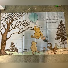 the winnie the pooh poster is hanging on the wall in front of a tree