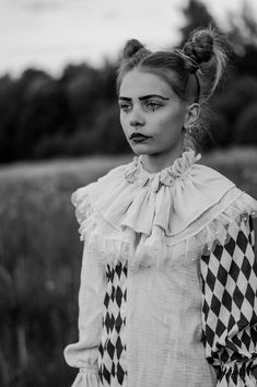 black and white photograph of a woman with makeup on her face wearing a checkered dress