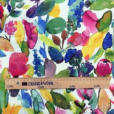 a ruler is next to a colorful floral print fabric