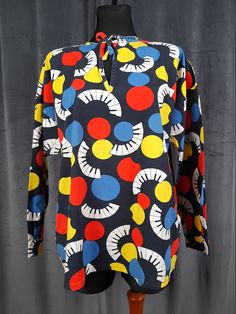 This is a beautiful vintage blouse made from cotton in the nineties. The pattern of the blouse is bright and colourful piano keys and circles. Perfect for music lovers! Excellent for your bohemian outfits! MAKE: This blouse was found in a Scandinavian vintage boutique which sells things made there. CONDITION: Good, there is a tiny rub on the blouse, see the last picture COMPOSITION: 100% cotton MEASUREMENTS:  The mannequin is size S. The measurements are taken lying flat and then doubled. Bust: Retro Long Sleeve Multicolor Print Top, Retro Red Printed Top, Colorful Retro Long Sleeve Tops, Colorful Long Sleeve Retro Tops, Retro Blue Top With Colorful Pattern, Red Cotton Tops With Colorful Pattern, Retro Patterned Top With Graphic Print, Retro Patterned Tops With Vibrant Print, Colorful Printed Retro Tops