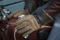 a close up of a person wearing gloves on a motorcycle