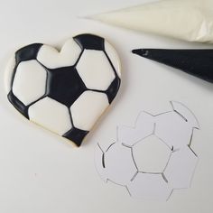 a cookie shaped like a soccer ball next to cut out shapes